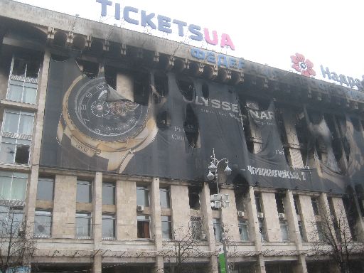 Partly burnt luxury watch billboard on the Trade Unions Building