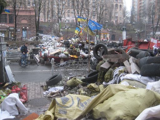 A closer look at the barricade, showing its make-up: tires, sandbags, bricks, signs, and a bed frame.